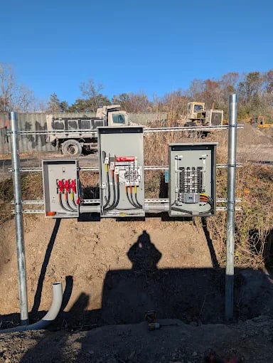 Electrical equipment and control panels mounted on metal frame in rural outdoor setting